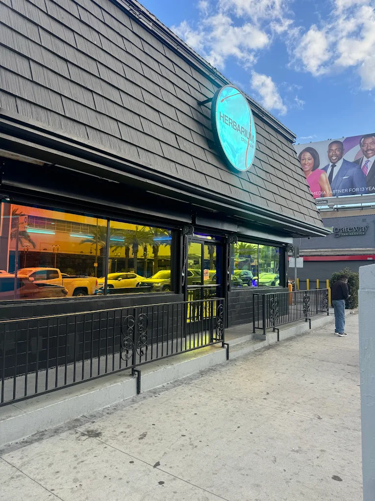 Crenshaw Legacy Herbarium storefront with blue circular sign and gray exterior